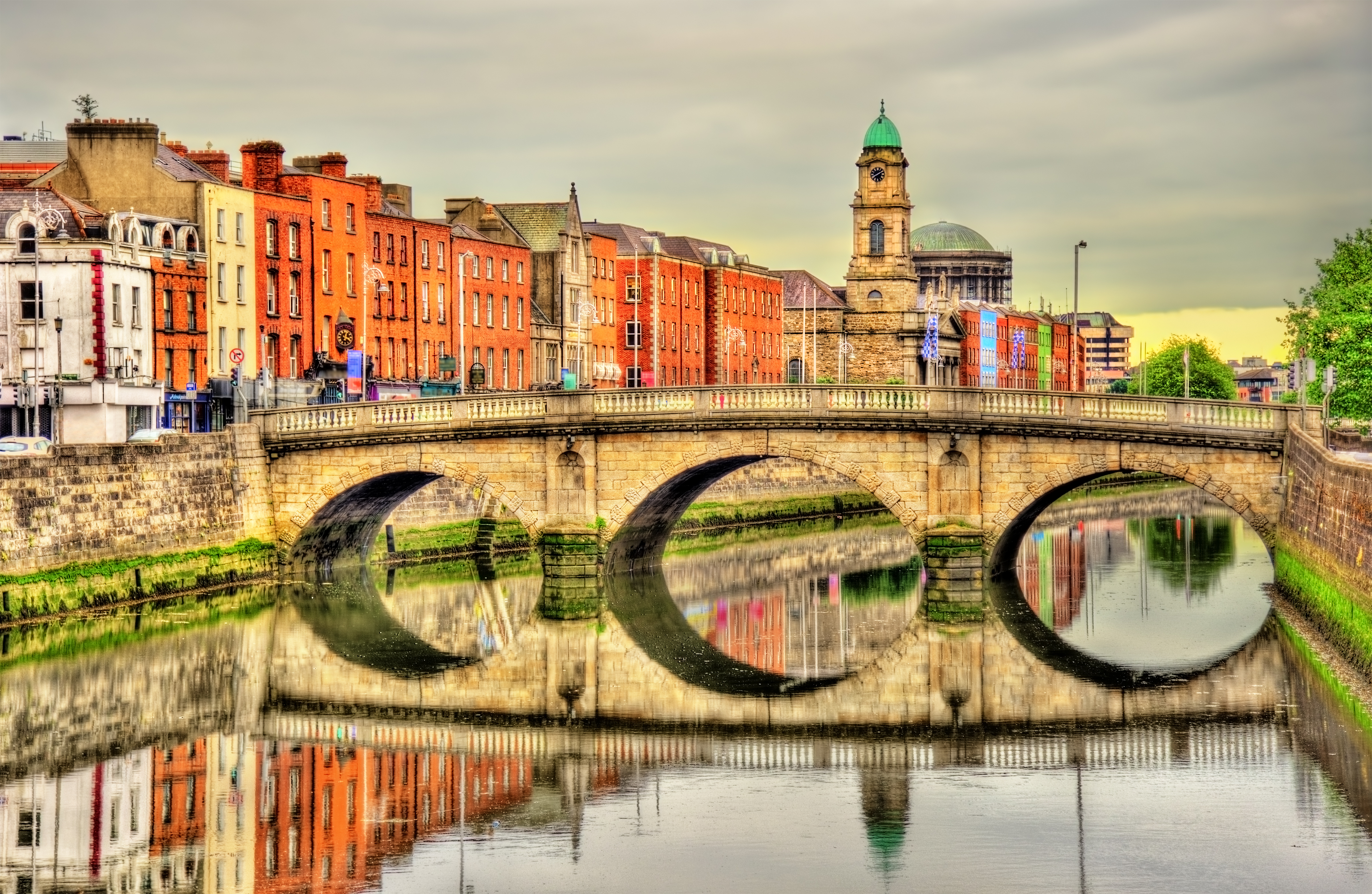 a bridge over a river with buildings in the background