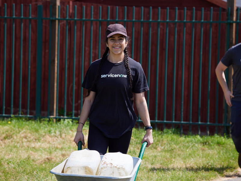 a person pushing a wheelbarrow with milk