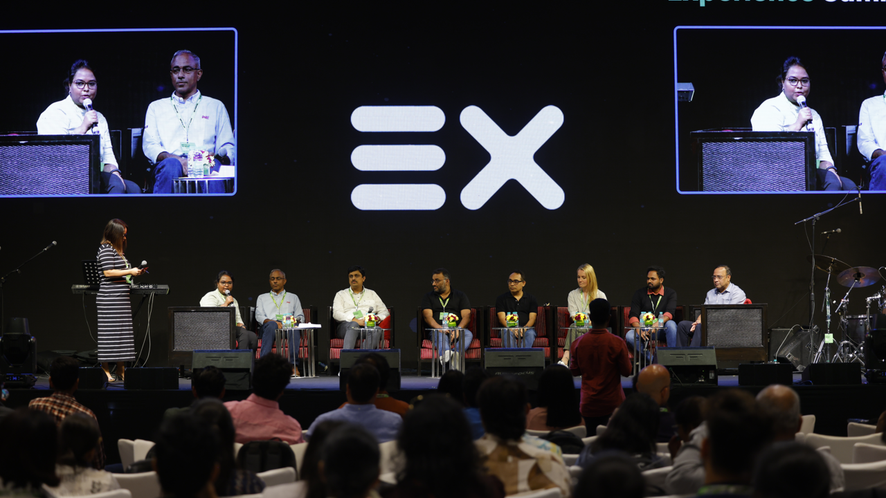 a group of people sitting in chairs in front of a large screen