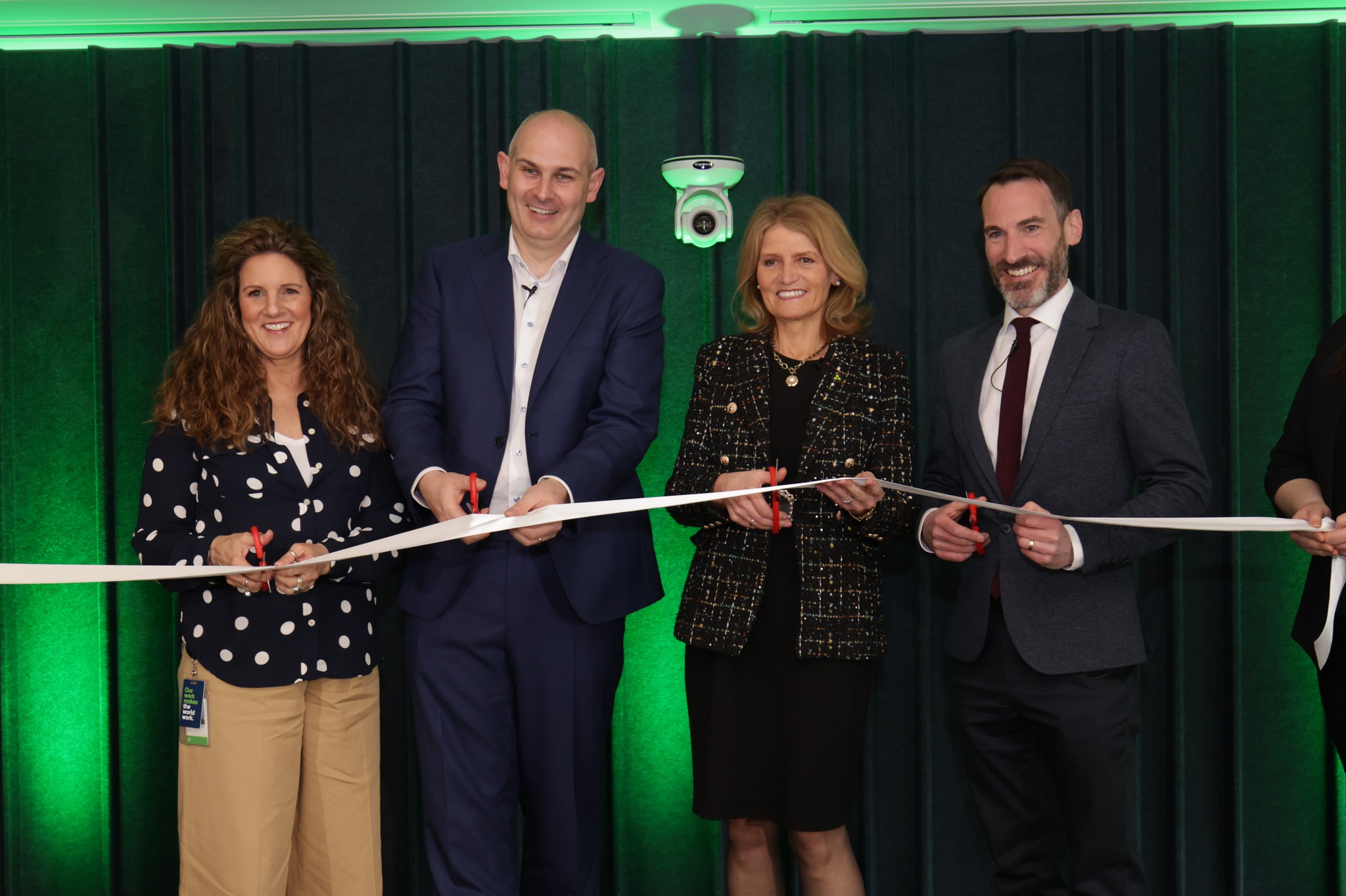 a group of people cutting a ribbon