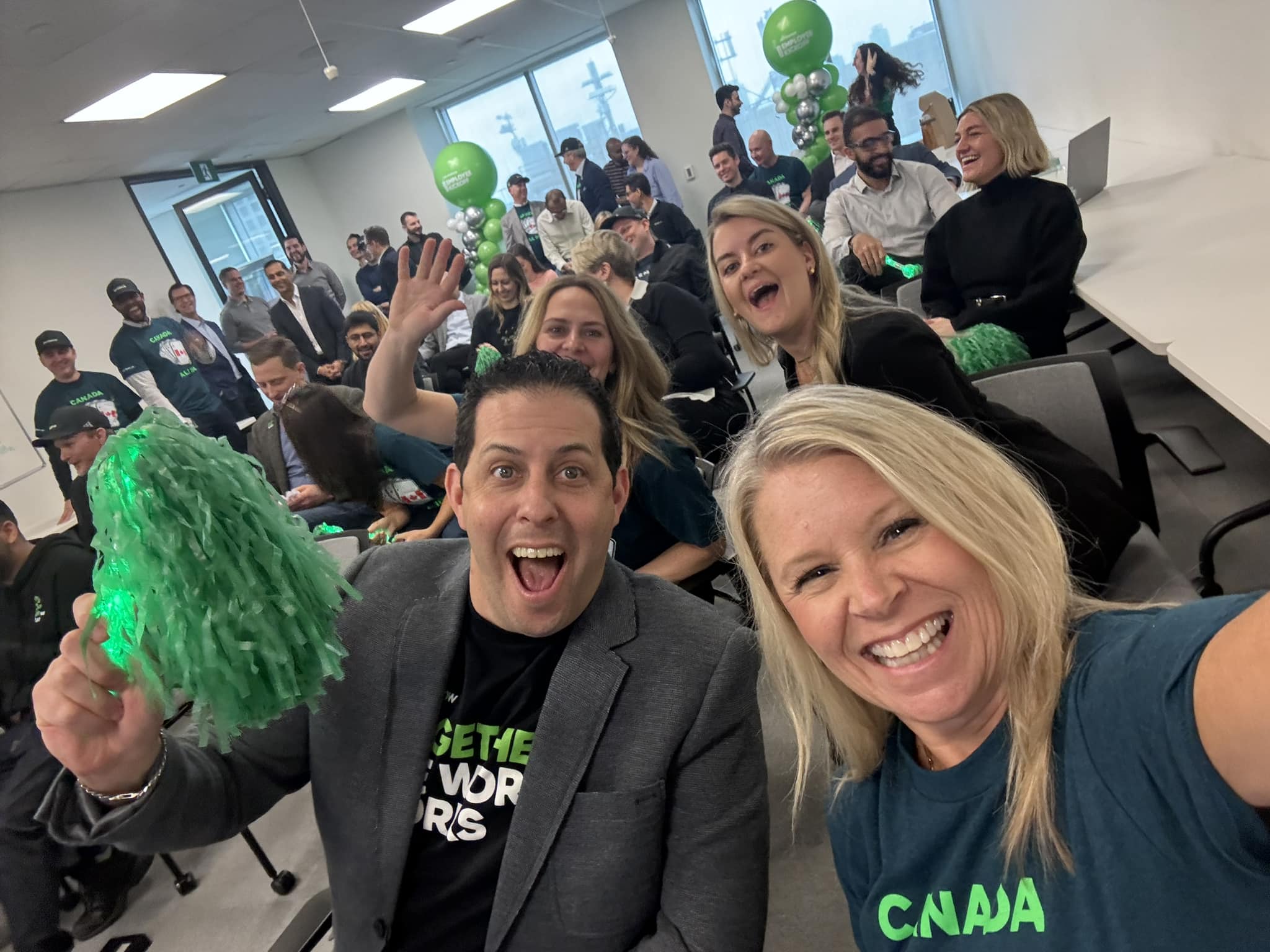 a group of people in a room with green pom poms