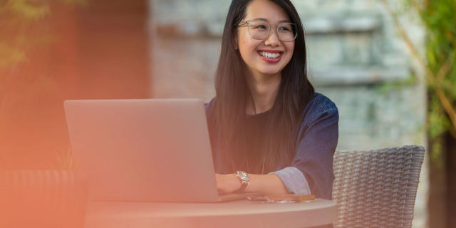 a person smiling at a laptop