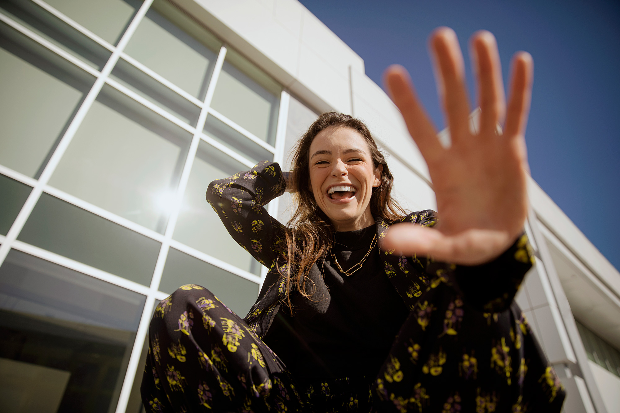 a person smiling and waving her hand