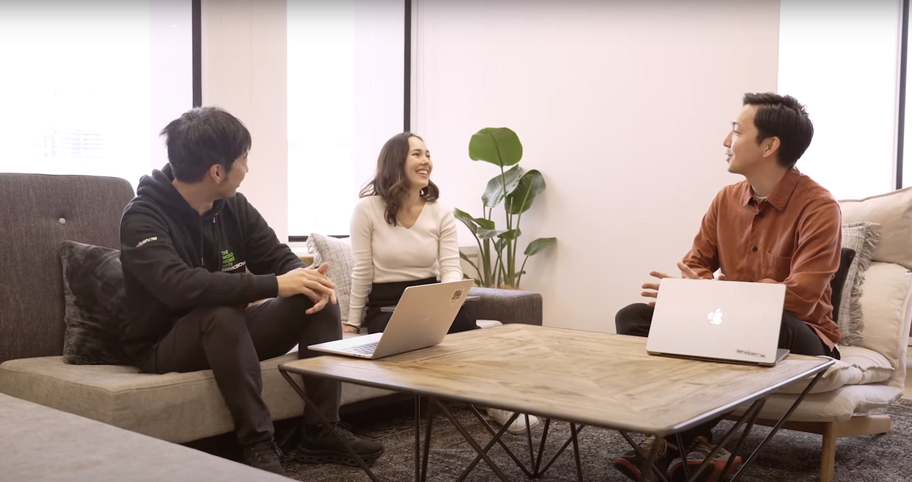 a group of people sitting on a couch and talking