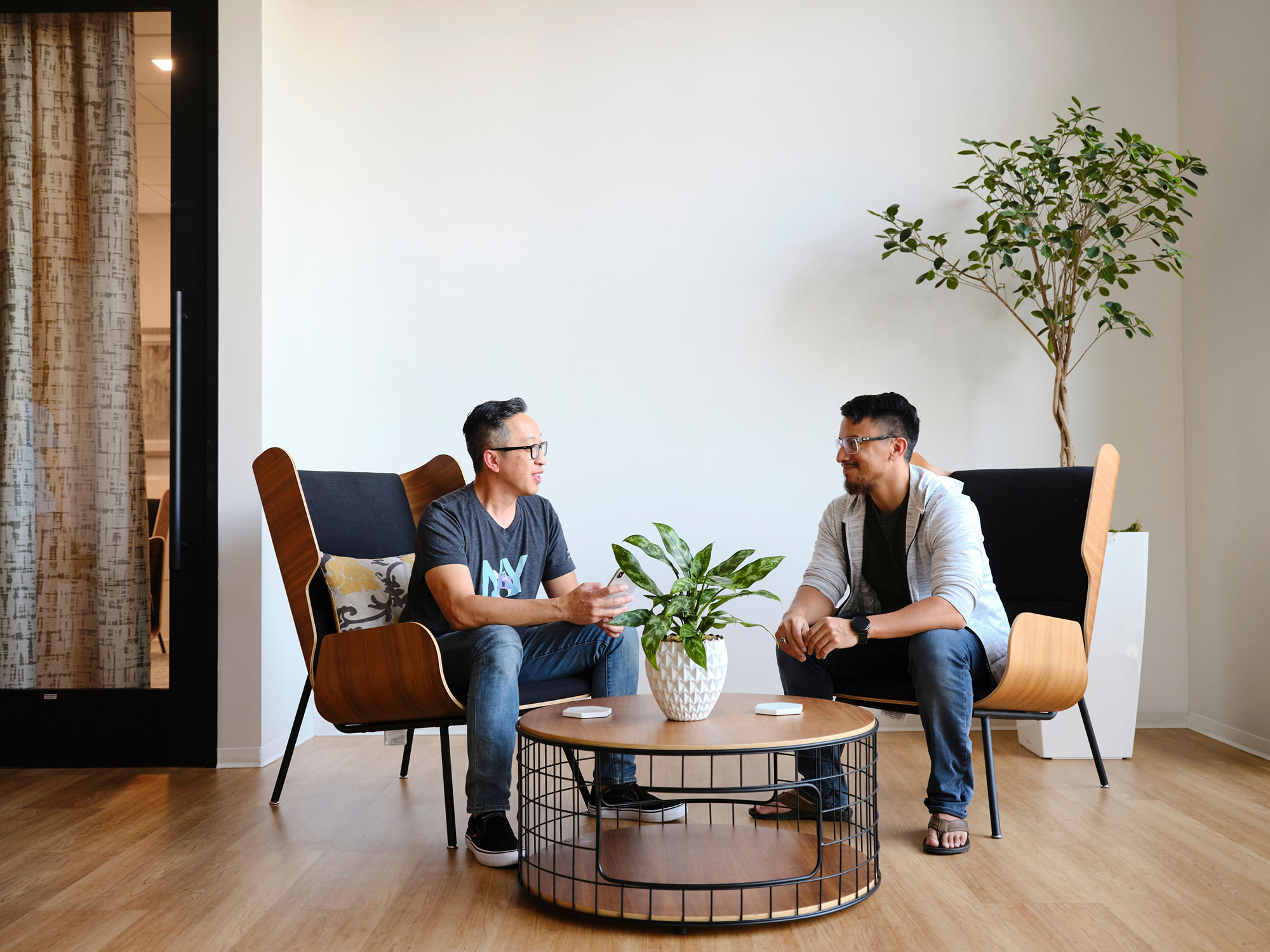 two men sitting in chairs and a coffee table