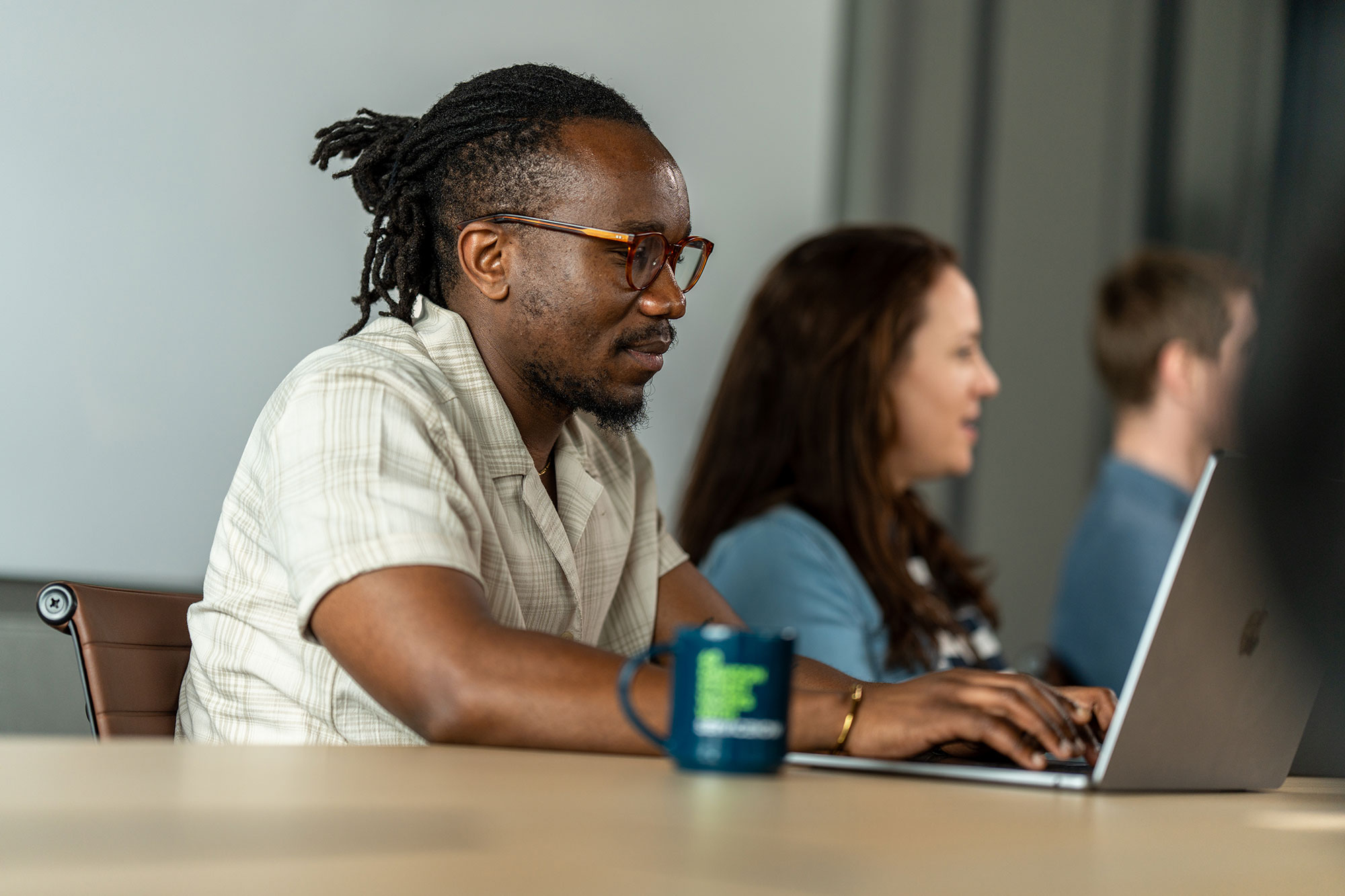 a person sitting at a table with a laptop