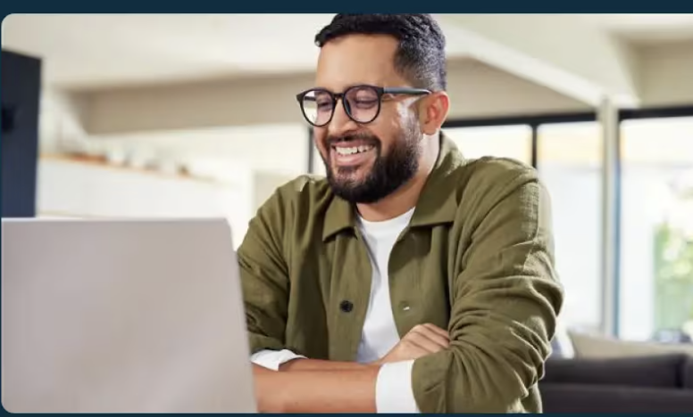 Thumbnail_Trailblazing the way forward with AI agents, a person smiling at a laptop