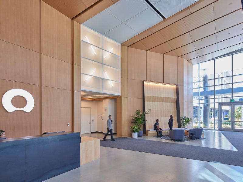 a lobby with a large window and a couple of people walking
