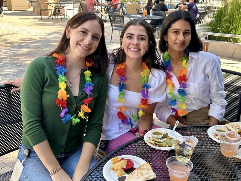 a group of women sitting at a table with food and drinks