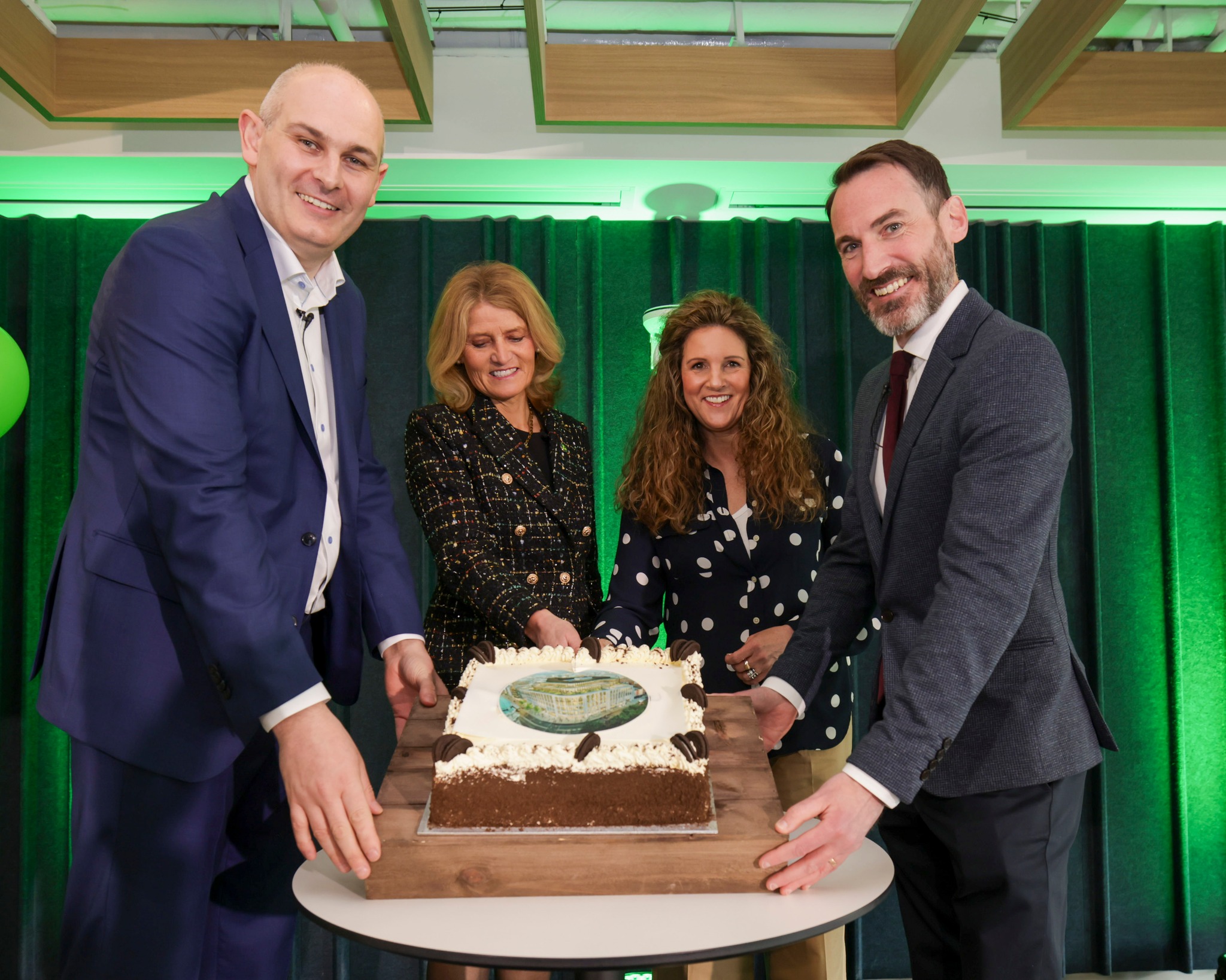 a group of people standing around a cake