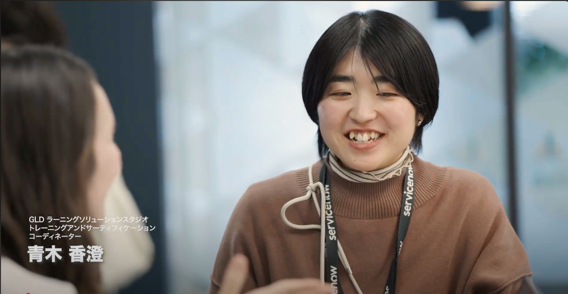 a person smiling with a lanyard around her neck