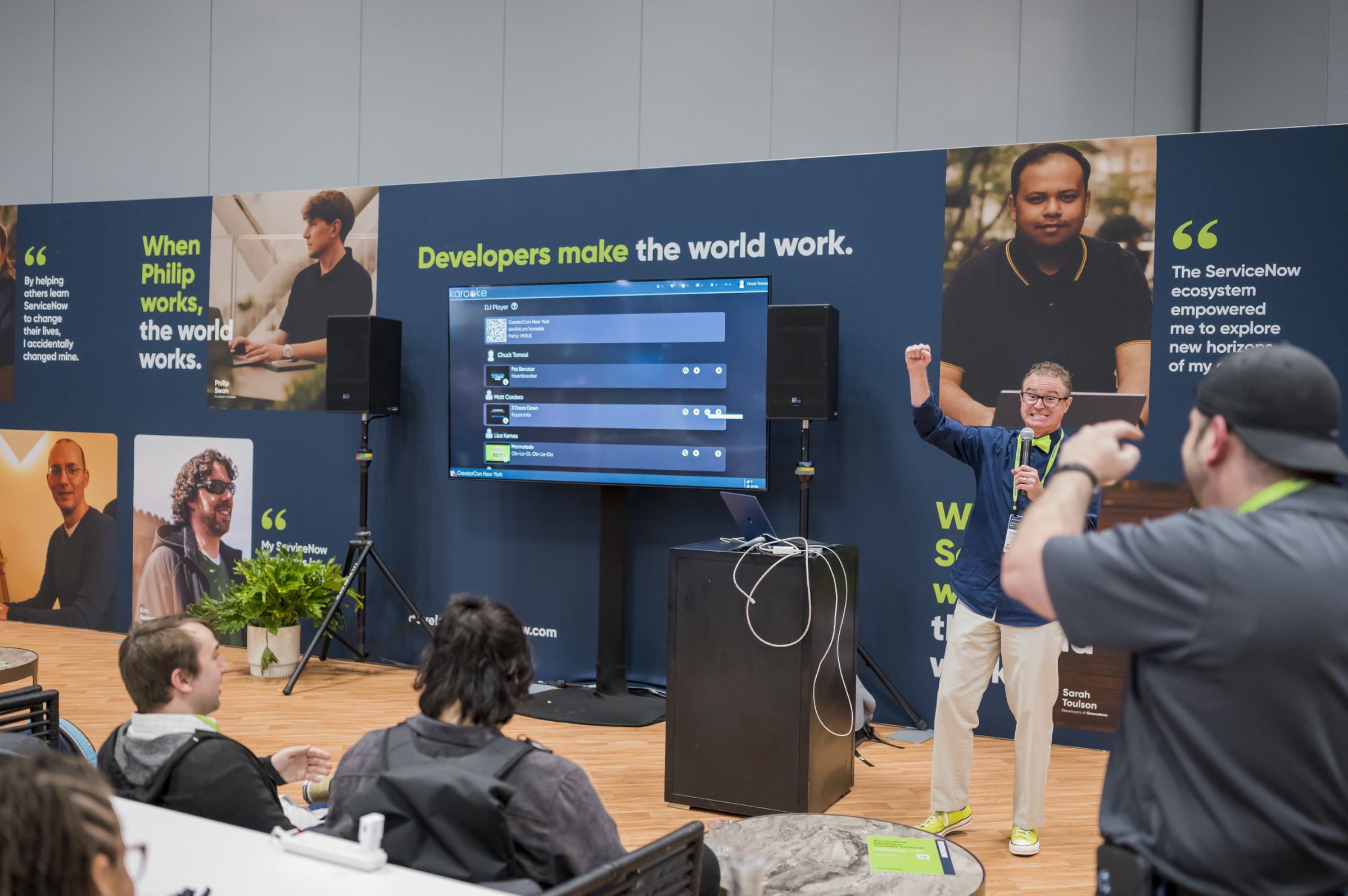 a person standing in front of a screen with a person raising his hand