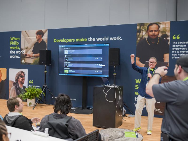 a person standing in front of a screen with a person raising his hand