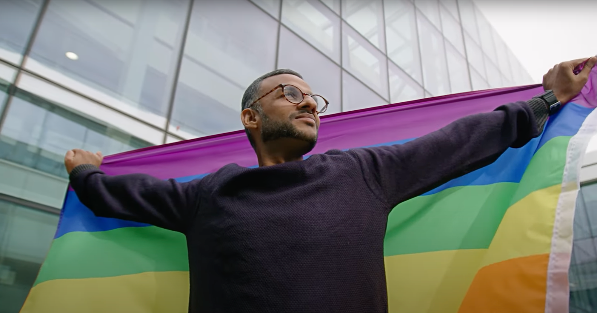 a person holding a rainbow flag