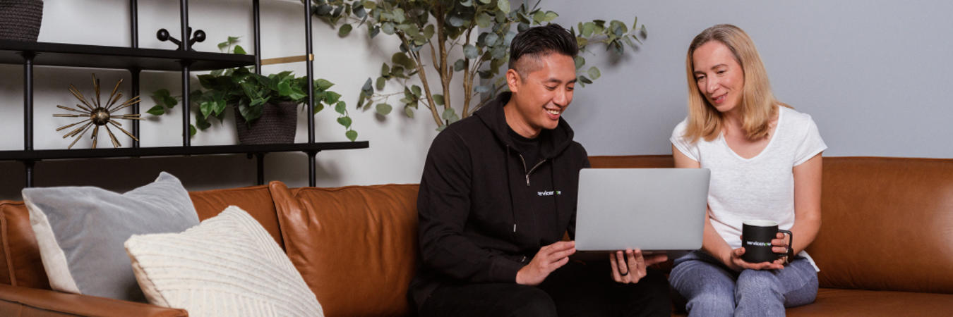 a person sitting on a couch holding a laptop
